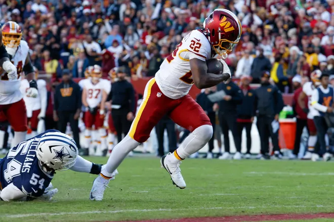 Dec 25, 2025; Landover, Maryland, USA; Washington Commanders running back Jacory Croskey-Merritt (22) avoids a tackle by Dallas Cowboys defensive end Sam Williams (54) to score a touchdown in the second quarter at Northwest Stadium. Mandatory Credit: Amber Searls-Imagn Images