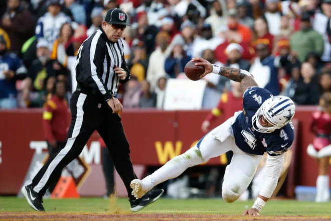 Dec 25, 2025; Landover, Maryland, USA; Dallas Cowboys quarterback Dak Prescott (4) falls to the field against the Washington Commanders in the third quarter at Northwest Stadium. Mandatory Credit: Amber Searls-Imagn Images