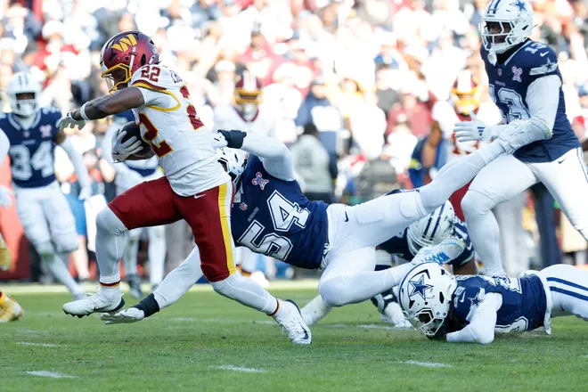 Dec 25, 2025; Landover, Maryland, USA; Washington Commanders running back Jacory Croskey-Merritt (22) avoids a tackle by Dallas Cowboys defensive end Sam Williams (54) as he carries the ball for a touchdown in the second quarter at Northwest Stadium. Mandatory Credit: Geoff Burke-Imagn Images