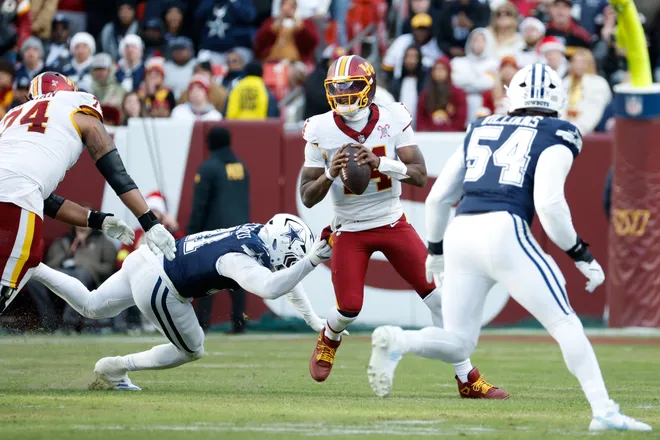 Dec 25, 2025; Landover, Maryland, USA; Washington Commanders quarterback Josh Johnson (14) looks to pass the ball under pressure from Dallas Cowboys defensive end Donovan Ezeiruaku (41) in the third quarter at Northwest Stadium. Mandatory Credit: Amber Searls-Imagn Images