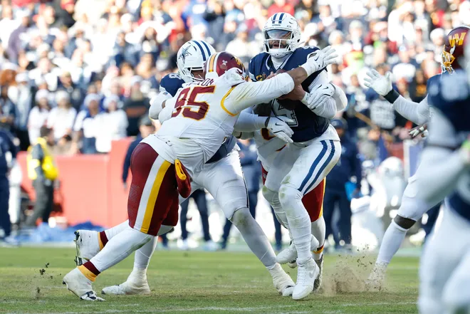 Dec 25, 2025; Landover, Maryland, USA; Washington Commanders quarterback Jayden Daniels (5) sacks Dallas Cowboys quarterback Dak Prescott (4) in the second quarter at Northwest Stadium. Mandatory Credit: Geoff Burke-Imagn Images