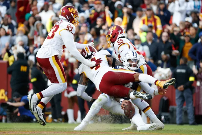 Dec 25, 2025; Landover, Maryland, USA; Washington Commanders defensive end Drake Jackson (93), linebacker Frankie Luvu (4) and Washington Commanders defensive end Jacob Martin (55) tackle Dallas Cowboys quarterback Dak Prescott (4) in the third quarter at Northwest Stadium. Mandatory Credit: Amber Searls-Imagn Images