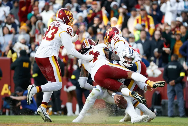 Dec 25, 2025; Landover, Maryland, USA; Washington Commanders defensive end Drake Jackson (93), linebacker Frankie Luvu (4) and Washington Commanders defensive end Jacob Martin (55) tackle Dallas Cowboys quarterback Dak Prescott (4) in the third quarter at Northwest Stadium. Mandatory Credit: Amber Searls-Imagn Images