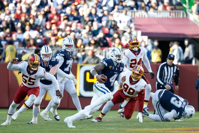 Dec 25, 2025; Landover, Maryland, USA; Dallas Cowboys quarterback Dak Prescott (4) scrambles with the ball against the Washington Commanders in the second quarter at Northwest Stadium. Mandatory Credit: Geoff Burke-Imagn Images