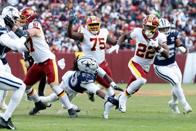 Dec 25, 2025; Landover, Maryland, USA; Washington Commanders running back Jacory Croskey-Merritt (22) carries the ball defended by Dallas Cowboys defensive end James Houston (53) in the third quarter at Northwest Stadium. Mandatory Credit: Amber Searls-Imagn Images