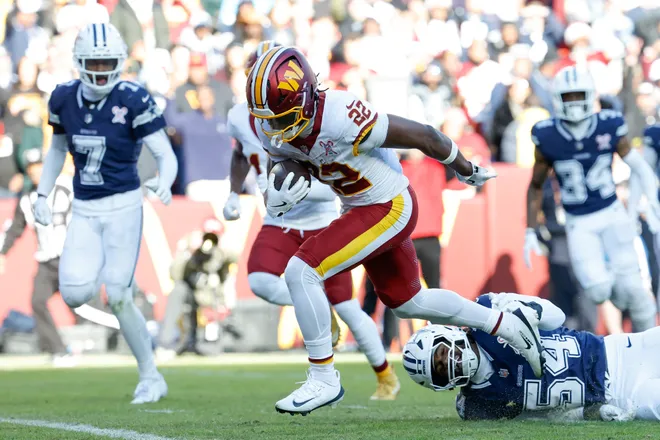 Dec 25, 2025; Landover, Maryland, USA; Washington Commanders running back Jacory Croskey-Merritt (22) avoids a tackle by Dallas Cowboys defensive end Sam Williams (54) as he carries the ball for a touchdown in the second quarter at Northwest Stadium. Mandatory Credit: Geoff Burke-Imagn Images