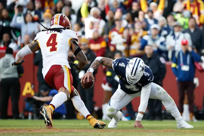 Dec 25, 2025; Landover, Maryland, USA; Dallas Cowboys quarterback Dak Prescott (4) falls to the field defended by Washington Commanders linebacker Frankie Luvu (4) in the third quarter at Northwest Stadium. Mandatory Credit: Amber Searls-Imagn Images