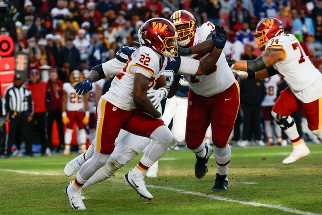 Dec 25, 2025; Landover, Maryland, USA; Washington Commanders running back Jacory Croskey-Merritt (22) carries the ball for a touchdown defended by Dallas Cowboys defensive tackle Quinnen Williams (92) in the third quarter at Northwest Stadium. Mandatory Credit: Geoff Burke-Imagn Images