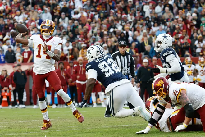 Dec 25, 2025; Landover, Maryland, USA; Washington Commanders quarterback Josh Johnson (14) passes the ball under pressure from Dallas Cowboys defensive tackle Quinnen Williams (92) in the third quarter at Northwest Stadium. Mandatory Credit: Geoff Burke-Imagn Images