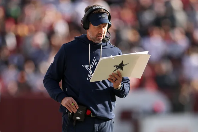 LANDOVER, MARYLAND - DECEMBER 25: Head coach Brian Schottenheimer of the Dallas Cowboys read his play calling sheet in the first quarter of a game against the Washington Commanders at Northwest Stadium on December 25, 2025 in Landover, Maryland. (Photo by Scott Taetsch/Getty Images)