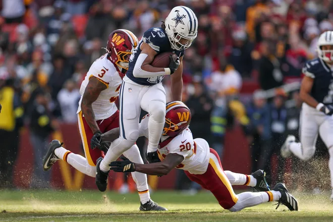 LANDOVER, MARYLAND - DECEMBER 25: Quan Martin #20 of the Washington Commanders tackles Malik Davis #43 of the Dallas Cowboys in the first quarter of a game at Northwest Stadium on December 25, 2025 in Landover, Maryland. (Photo by Scott Taetsch/Getty Images)