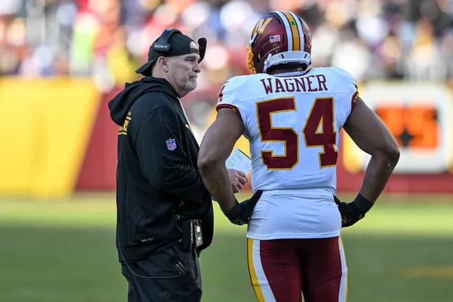 LANDOVER, MARYLAND - DECEMBER 25: Head coach Dan Quinn and Bobby Wagner #54 of the Washington Commanders talk in the second quarter of a game against the Dallas Cowboys at Northwest Stadium on December 25, 2025 in Landover, Maryland. (Photo by Greg Fiume/Getty Images)