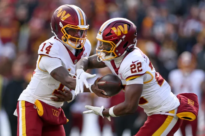 LANDOVER, MARYLAND - DECEMBER 25: Josh Johnson #14 hands the ball off to Jacory Croskey-Merritt #22 of the Washington Commanders in the first quarter of a game against the Dallas Cowboys at Northwest Stadium on December 25, 2025 in Landover, Maryland. (Photo by Scott Taetsch/Getty Images)