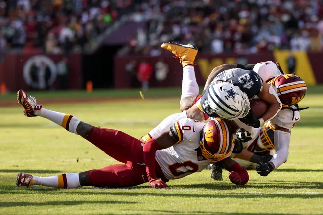 LANDOVER, MARYLAND - DECEMBER 25: Mike Sainristil #0 of the Washington Commanders tackles Malik Davis #43 of the Dallas Cowboys in the second quarter of a game at Northwest Stadium on December 25, 2025 in Landover, Maryland. (Photo by Scott Taetsch/Getty Images)