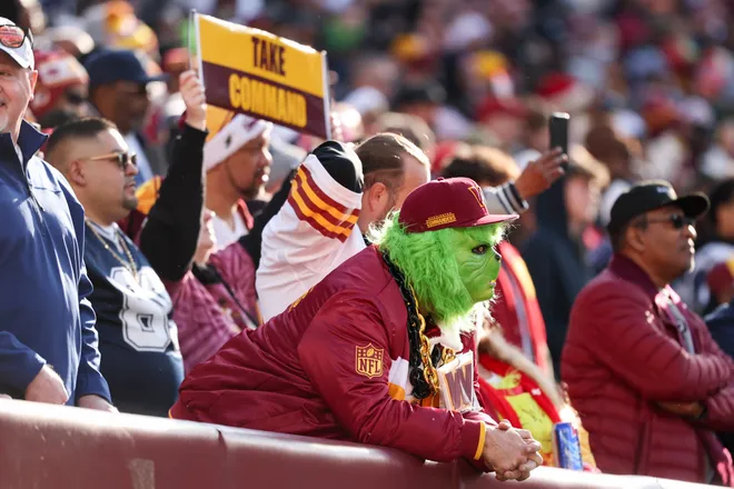 LANDOVER, MARYLAND - DECEMBER 25: A Washington Commanders fan dressed as The Grinch looks on in the second quarter of a game against the Dallas Cowboys at Northwest Stadium on December 25, 2025 in Landover, Maryland. (Photo by Scott Taetsch/Getty Images)