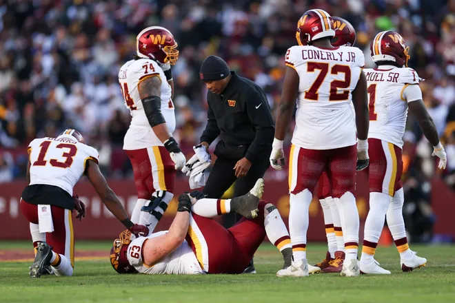 LANDOVER, MARYLAND - DECEMBER 25: Tyler Biadasz #63 of the Washington Commanders is looked at by medical staff in the second quarter of a game against the Dallas Cowboys at Northwest Stadium on December 25, 2025 in Landover, Maryland. (Photo by Scott Taetsch/Getty Images)
