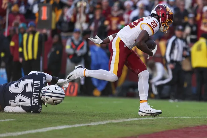LANDOVER, MARYLAND - DECEMBER 25: Jacory Croskey-Merritt #22 of the Washington Commanders scores a rushing touchdown against Sam Williams #54 of the Dallas Cowboys in the second quarter of a game at Northwest Stadium on December 25, 2025 in Landover, Maryland. (Photo by Scott Taetsch/Getty Images)