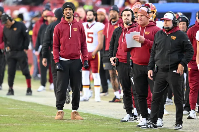 LANDOVER, MARYLAND - DECEMBER 25: Jayden Daniels #5 of the Washington Commanders looks on from the sideline in the second quarter of a game against the Dallas Cowboys at Northwest Stadium on December 25, 2025 in Landover, Maryland. (Photo by Greg Fiume/Getty Images)