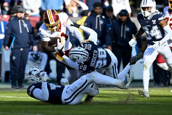 LANDOVER, MARYLAND - DECEMBER 25: Malik Hooker #28 of the Dallas Cowboys tackles Deebo Samuel #1 of the Washington Commanders in the second quarter of a game at Northwest Stadium on December 25, 2025 in Landover, Maryland. (Photo by Greg Fiume/Getty Images)