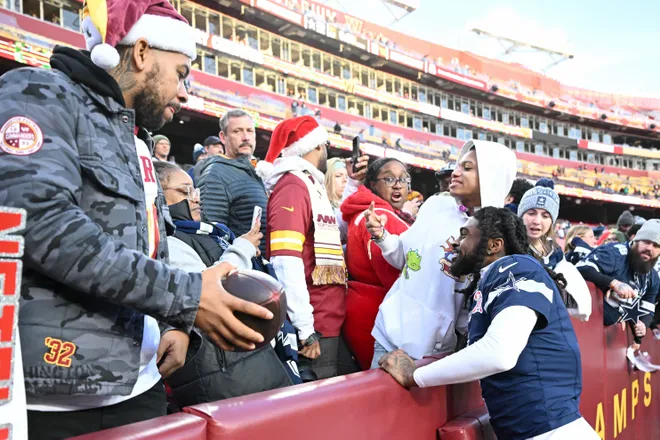 LANDOVER, MARYLAND - DECEMBER 25: Trevon Diggs #7 of the Dallas Cowboys takes a photo with a fan after his team's 30-23 victory against the Washington Commanders at Northwest Stadium on December 25, 2025 in Landover, Maryland. (Photo by Greg Fiume/Getty Images)
