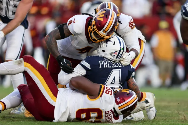 LANDOVER, MARYLAND - DECEMBER 25: Frankie Luvu #4 and Ricky Barber #66 of the Washington Commanders sack Dak Prescott #4 of the Dallas Cowboys in the fourth quarter of a game at Northwest Stadium on December 25, 2025 in Landover, Maryland. (Photo by Scott Taetsch/Getty Images)