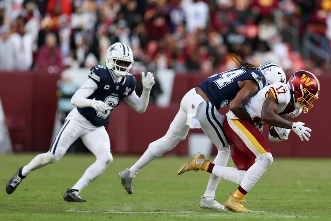 LANDOVER, MARYLAND - DECEMBER 25: Shavon Revel Jr. #34 of the Dallas Cowboys tackles Terry McLaurin #17 of the Washington Commanders in the fourth quarter of a game at Northwest Stadium on December 25, 2025 in Landover, Maryland. (Photo by Scott Taetsch/Getty Images)