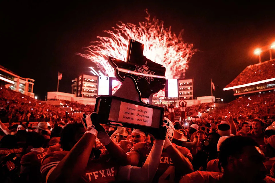 The Texas Longhorns hoist the trophy to celebrate winning the Lone Star Showdown 27-17 over the Texas A&M Aggies at Darrell K Royal–Texas Memorial Stadium in Austin, Nov. 28, 2025. (Sara Diggins/Austin American-Statesman)