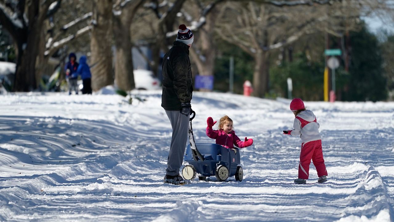 Craig Crow, left, walk through the snow with his daughters, Elizabeth, center, and Olivia, right, Monday, Feb. 15, 2021, in San Antonio. San Antonio received 3-5 inches of snow over night. (AP Photo/Eric Gay)
