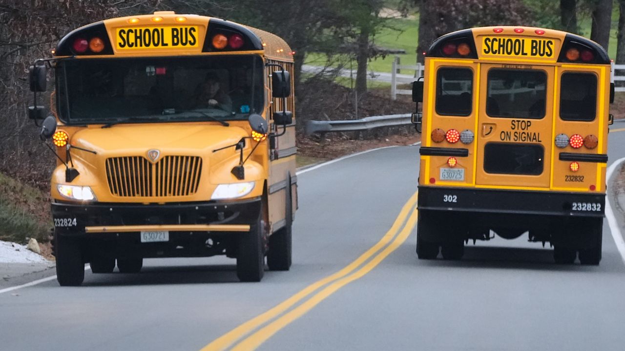 School buses pass on a road, Tuesday, Nov. 25, 2025, in Atkinson, N.H. (AP Photo/Charles Krupa)