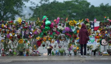 A visitor views a memorial wall for flood victims, Sunday, July 13, 2025, in Kerrville, Texas. (AP Photo/Eric Gay)