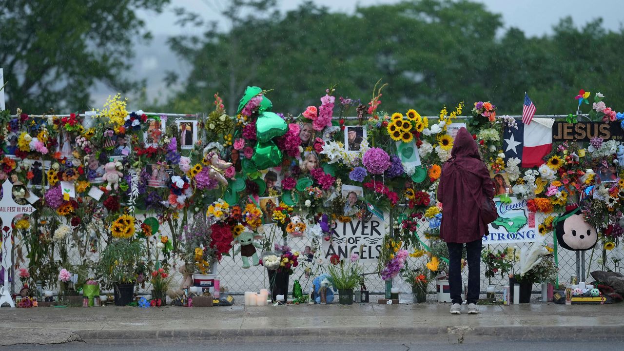 A visitor views a memorial wall for flood victims, Sunday, July 13, 2025, in Kerrville, Texas. (AP Photo/Eric Gay)