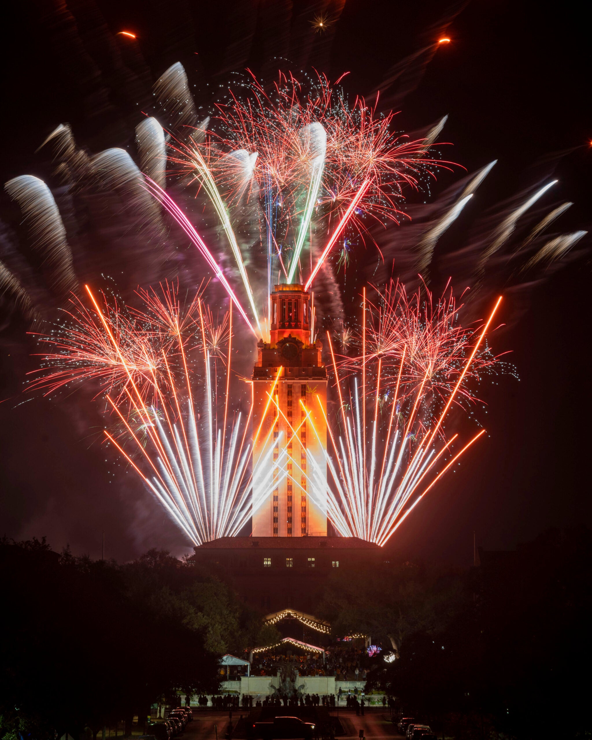 image of the Tower lit up in orange with fireworks on all sides
