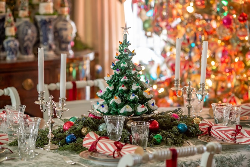 Close up of dining table with Christmas tree centerpiece, Christmas crackers, dishes