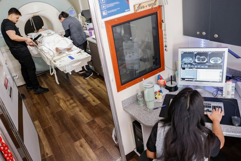 Raymond Marroquin (left) and Maggie Ortiz-Munoz (center) adjust Rylie Baker (center left),...