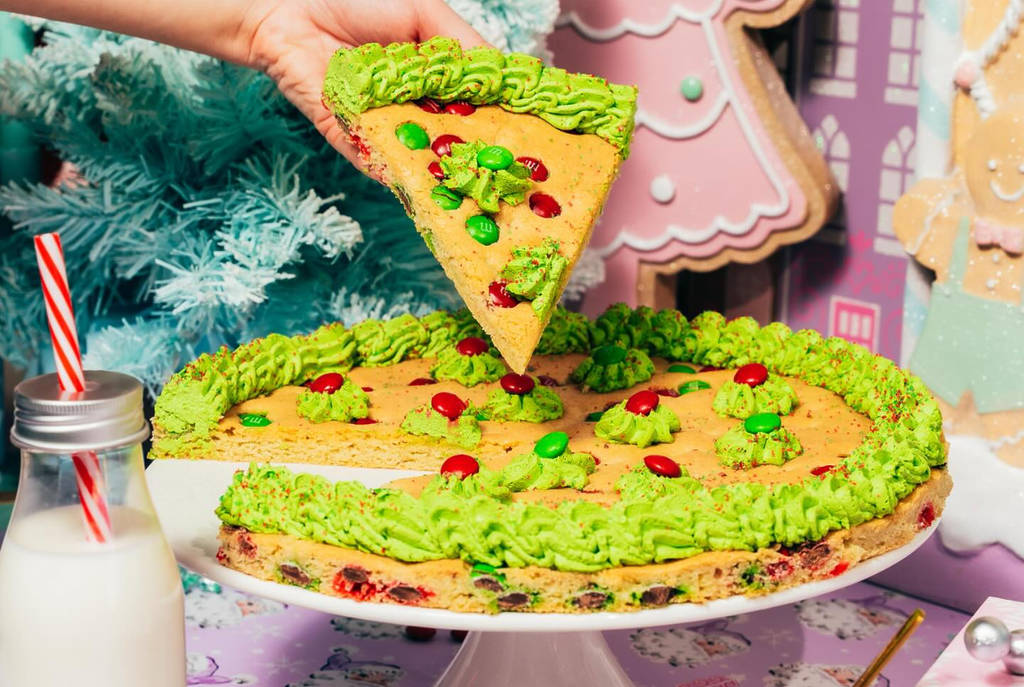 Image shows a holiday-themed cookie cake surrounded by whimsical decor at the Land of Sweets holiday pop-up in DFW.