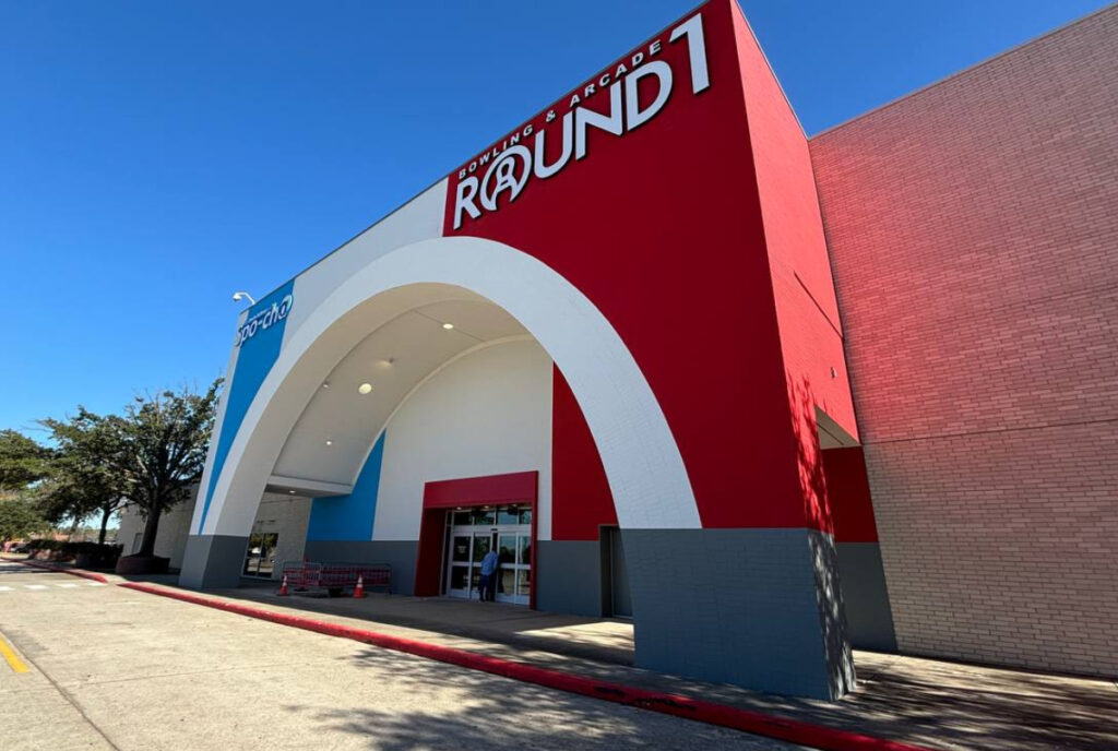 Image shows exterior of Round1 Bowling & Arcade featuring an arched facade.