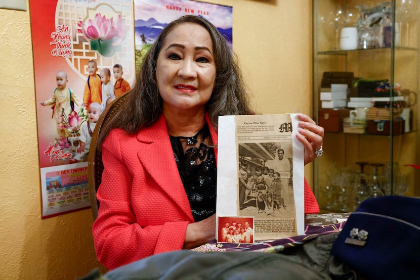 Jennifer Nguyen holds a newspaper clipping with a family photo taken after their arrival in...