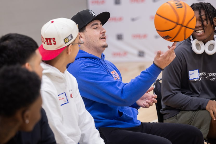 Participant Riley Webb, 22, spins a basketball as he introduces himself during Coach Referee...