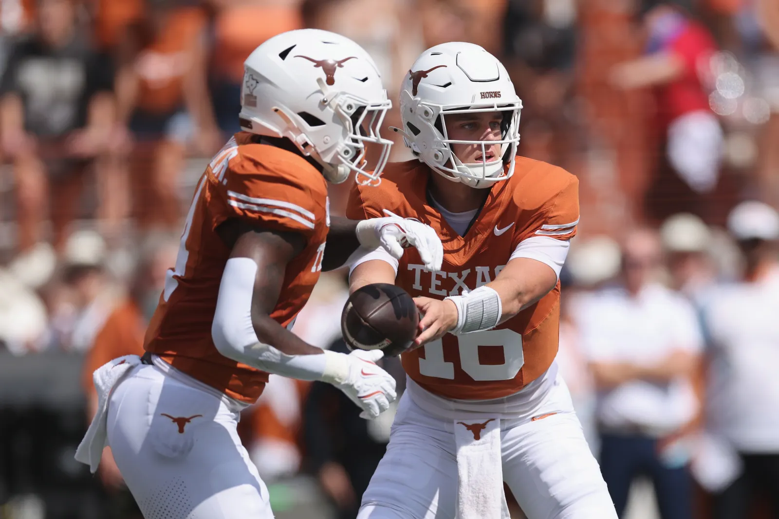 Arch Manning #16 of the Texas Longhorns hands off to CJ Baxter