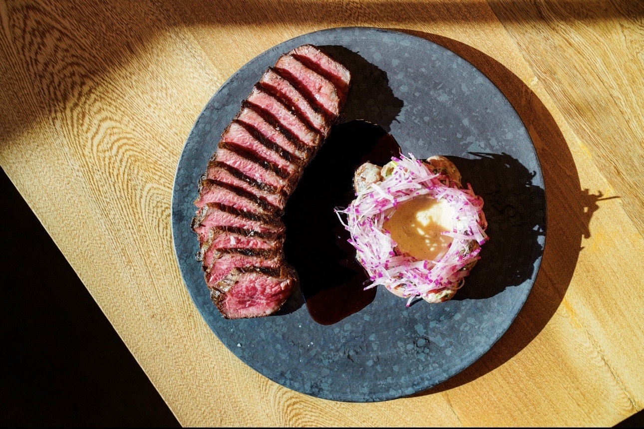 Steak on a black plate.