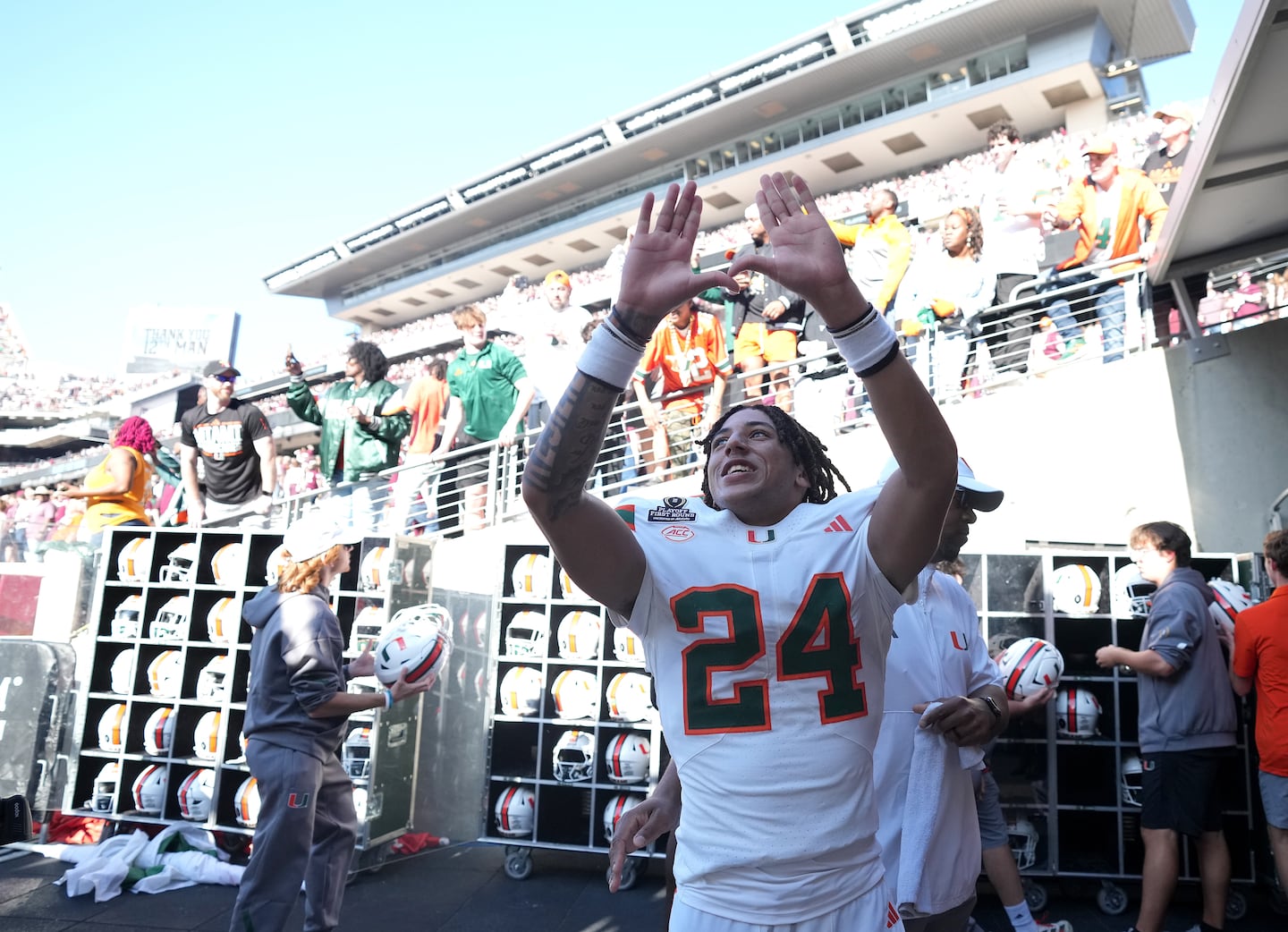 Miami defensive back Ethan O'Connor (24) celebrates Miami's win over Texas A&M with fans in the tunnel.