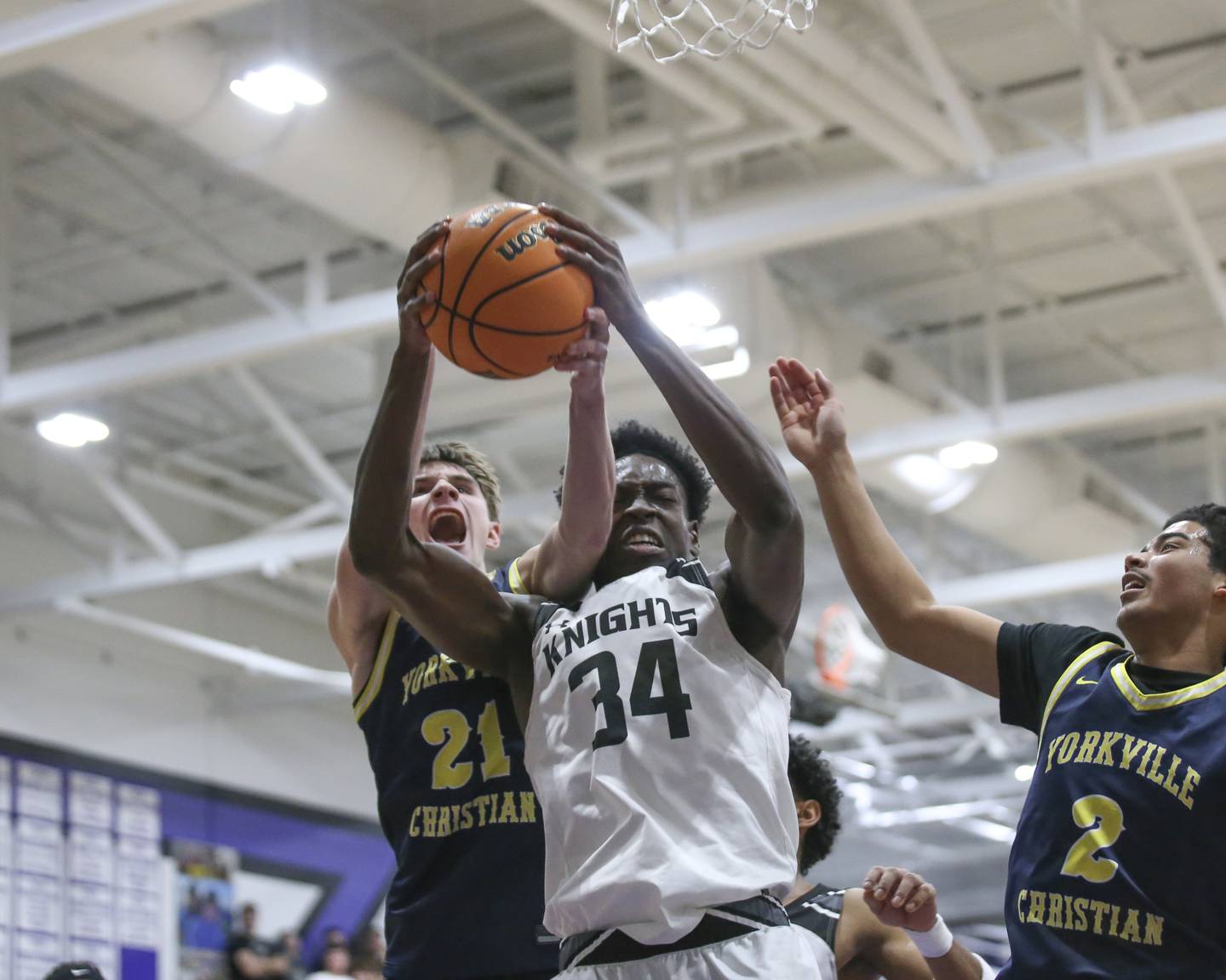 Yorkville Christian's Jordan Purvis (21) and Kaneland's Jeffrey Hassan (34) fight for a rebound during their Plano Christmas Classic Championship basketball game between Yorkville Christian at Kaneland Tuesday, Dec 30, 2025 in Plano.