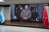 A screen displays an image of former Honduran president Juan Orlando Hernandez, pardoned by...