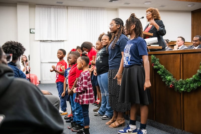 Children from the Fort Worth Save our Children Learning Center sing songs they learned at the Learning Center that help them memorize scriptures, planets, continents and oceans at the Saints in Unity devotional in Fort Worth, Texas, on Nov. 16, 2025.