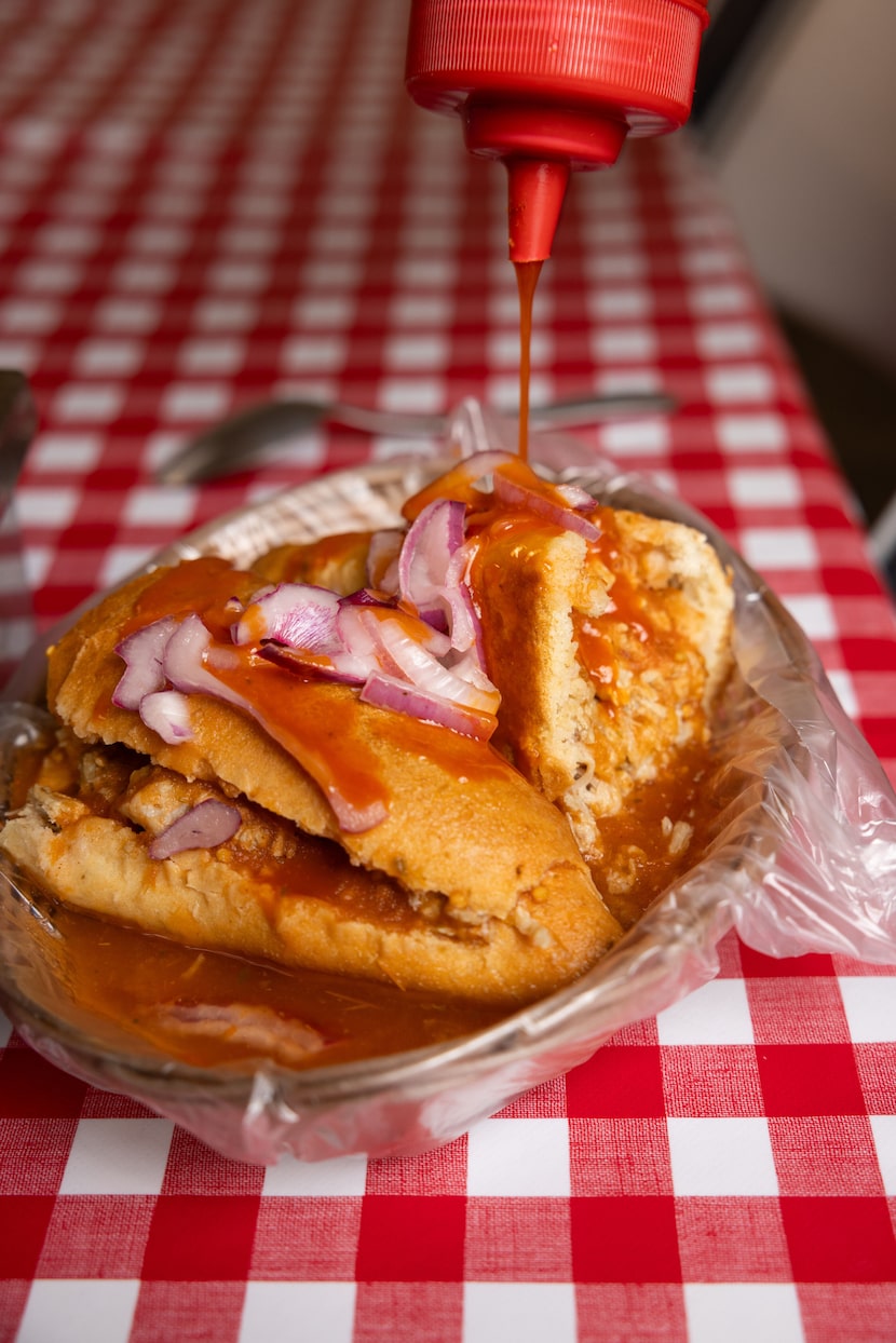 Customer Jairo Gonzalez prepares his tortas ahogadas to his liking at Tortas Ahogadas...