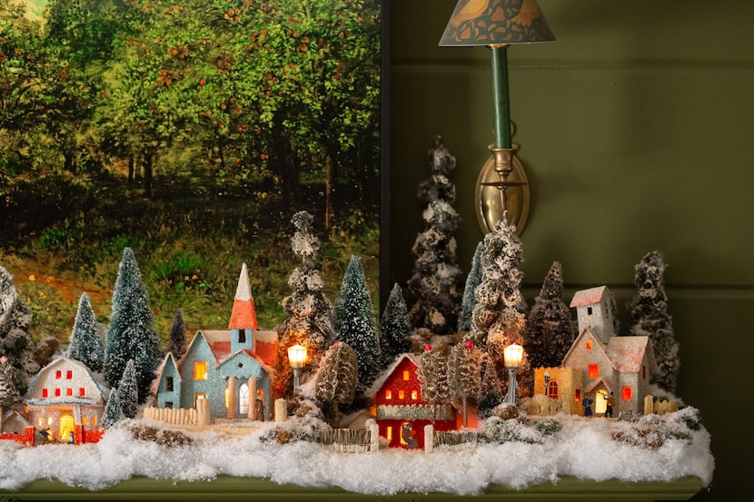 Small cardboard houses decorated in colorful themes, with bottle-brush trees and snowy...