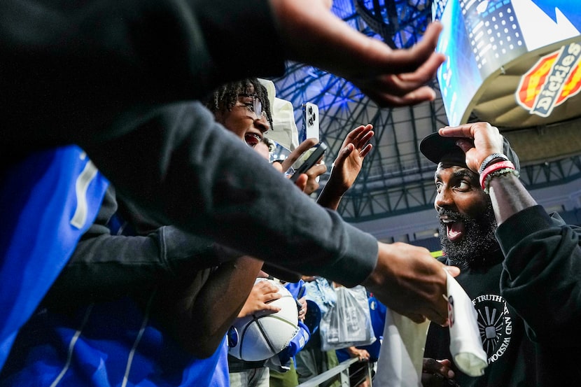 Dallas Mavericks guard Kyrie Irving signs autographs after an NBA preseason basketball game...