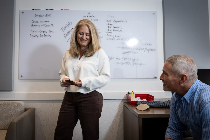 Nancy Hairston, MedCAD president and CEO, looks at a cranial implant with Alan Klompus,...
