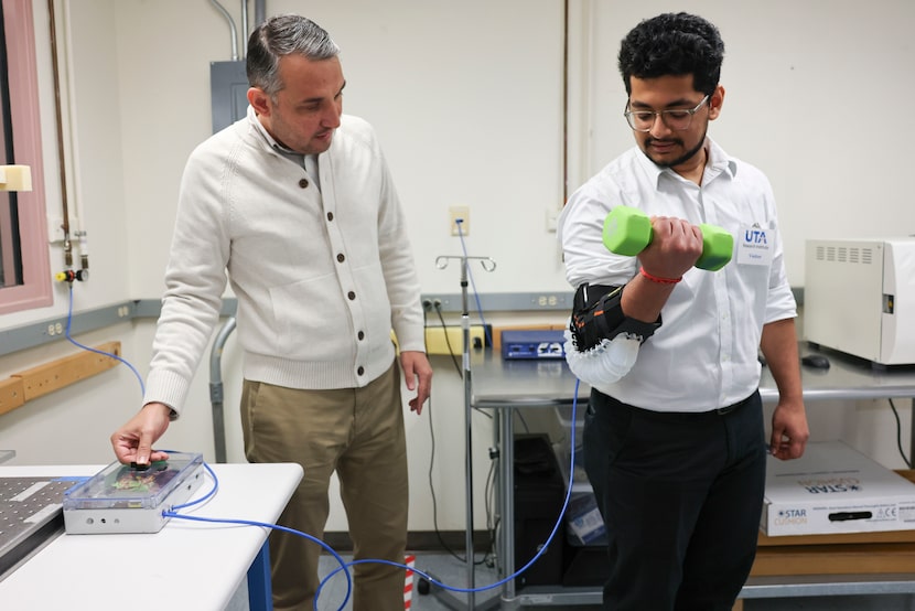 Research scientist Veysel Erel (left) demonstrates the air-powered wearable elbow...
