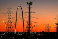 The Margaret Hunt Hill Bridge is seen behind high transmission power lines running along...